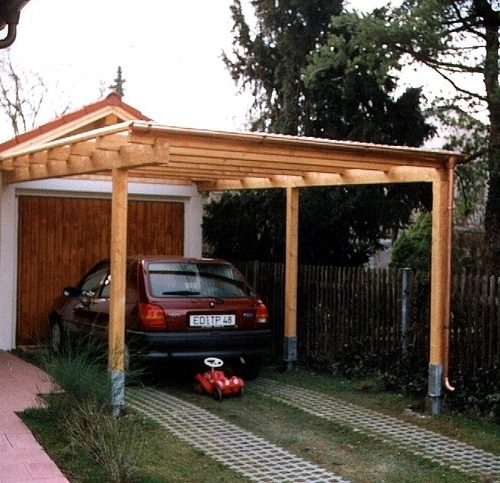 Auto steht geschützt unter Carport aus Holz