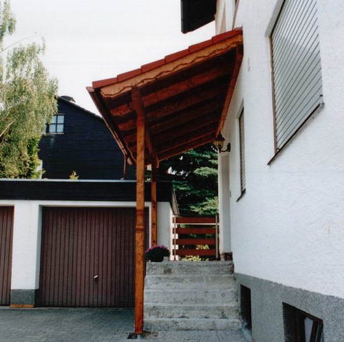 Haustüre und Treppenstufen mit Vordach aus Holz