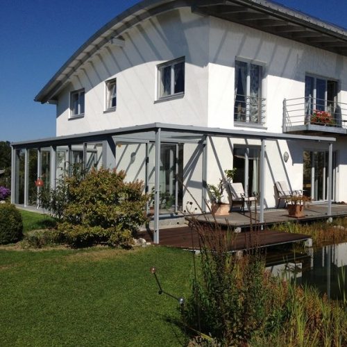 Haus mit Wintergarten und Terrassenüberdachung aus Alu und Glas