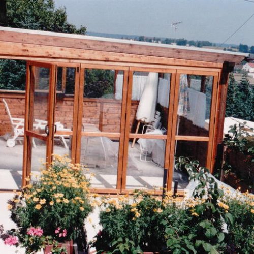 gemüticher Wintergarten aus Holz mit Fenstern und Schiebetüren