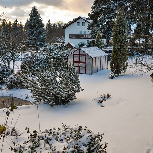 Winter Gewächshaus im Garten mit viel Schnee