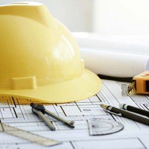 Gelber Bauarbeiterhelm auf Bauzeichnung mit Baugenehmigung