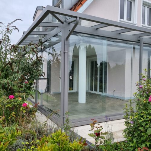 Ein verglaster Sommergarten / Wintergarten mit grauen Rahmen
