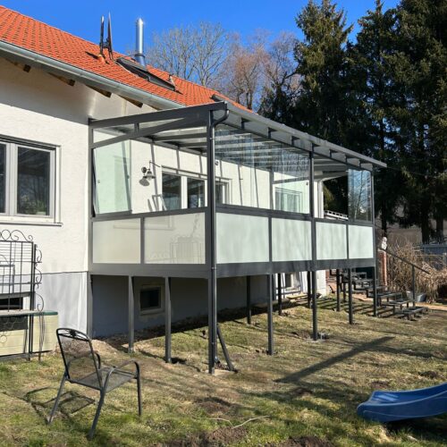 Ein Haus mit einer verglasten Terrasse als Sommergarten / Wintergarten in München