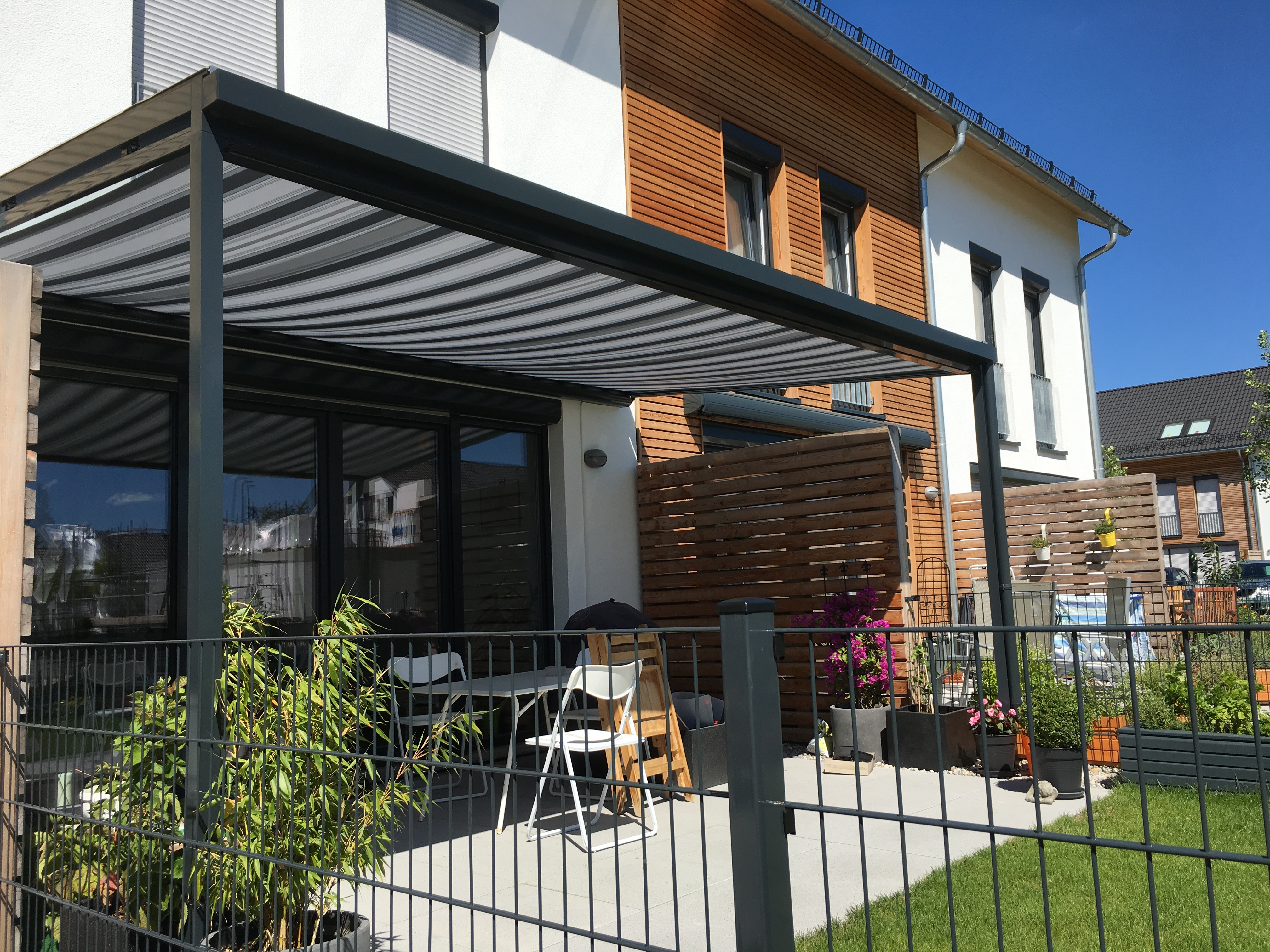 Moderne Terrassenüberdachung in München aus Aluminium mit Sonnenblende
