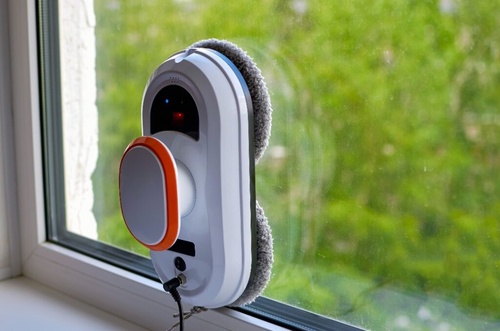 Ein Roboter-Staubsauger reinigt ein verschmutztes Fenster.